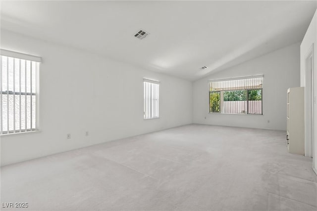 empty room featuring lofted ceiling and light colored carpet