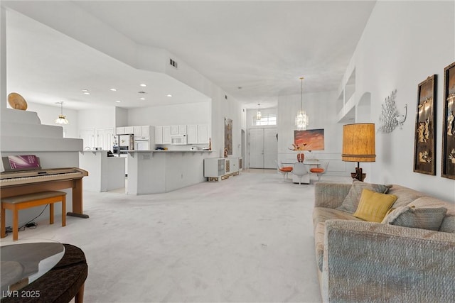 living area with light colored carpet and recessed lighting