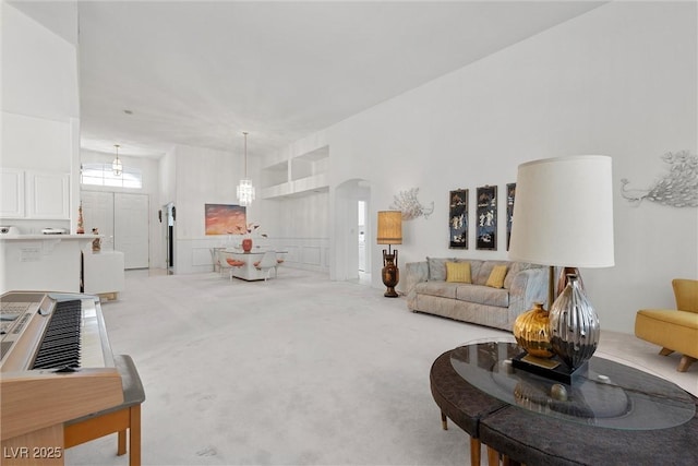 carpeted living area featuring arched walkways