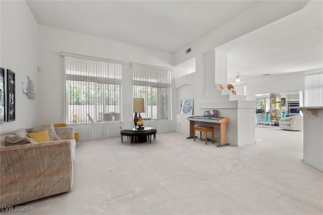 carpeted living room with plenty of natural light and a ceiling fan