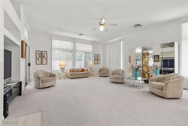 carpeted living area with a ceiling fan