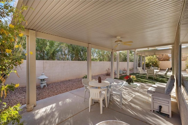 view of patio with outdoor dining space, ceiling fan, and a fenced backyard