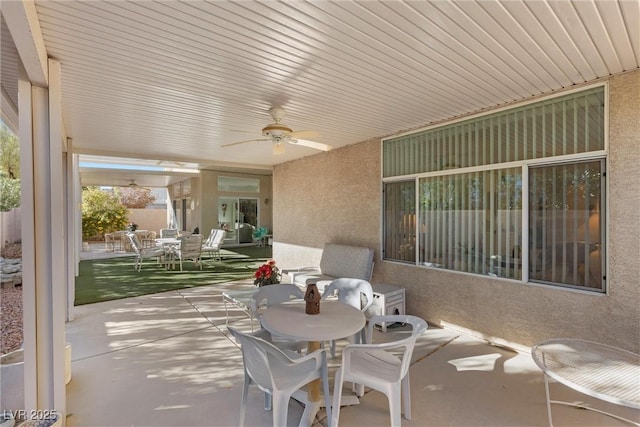 view of patio with outdoor dining space and ceiling fan