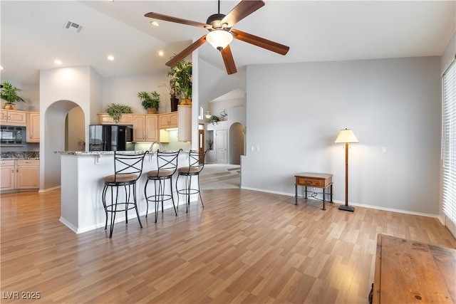 1933 Davina St, Henderson, NV 89074 - kitchen featuring arched walkways, black appliances, a breakfast bar area, ceiling fan, and light wood finished floors