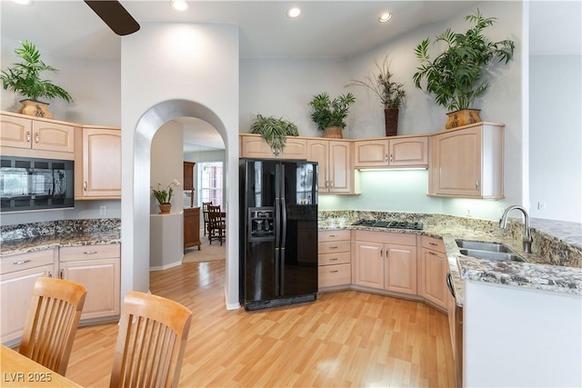 1933 Davina St, Henderson, NV 89074 - kitchen featuring black appliances, a sink, light brown cabinets, light stone counters, and arched walkways