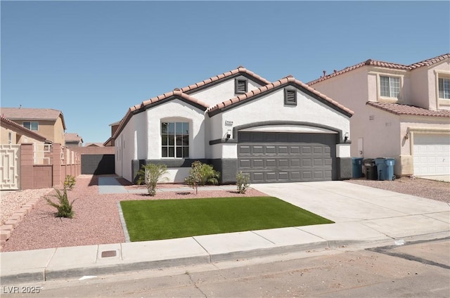 mediterranean / spanish house featuring a tile roof, stucco siding, concrete driveway, a garage, and a gate