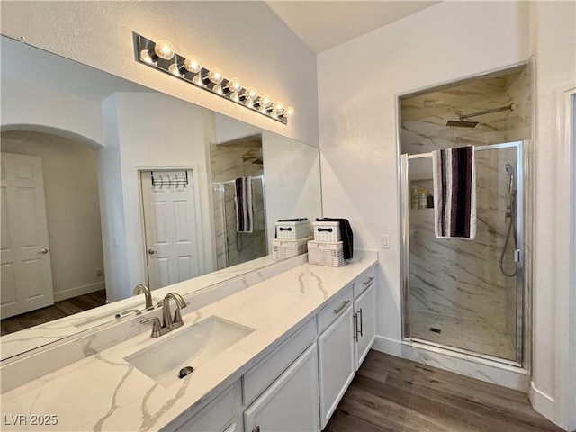 5422 Nestled Moon Ct, Las Vegas, NV 89131 - bathroom featuring vanity, a marble finish shower, wood finished floors, and baseboards