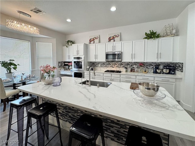 5422 Nestled Moon Ct, Las Vegas, NV 89131 - kitchen with appliances with stainless steel finishes, a sink, decorative backsplash, white cabinets, and recessed lighting