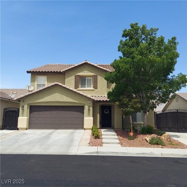 view of front of house with a tile roof, stucco siding, concrete driveway, fence, and a gate