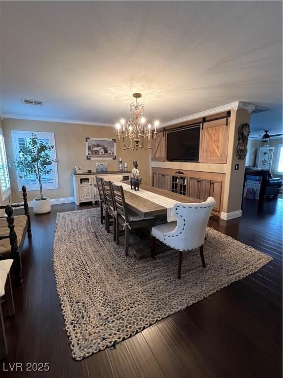dining space with a chandelier, ornamental molding, dark wood-type flooring, baseboards, and a barn door