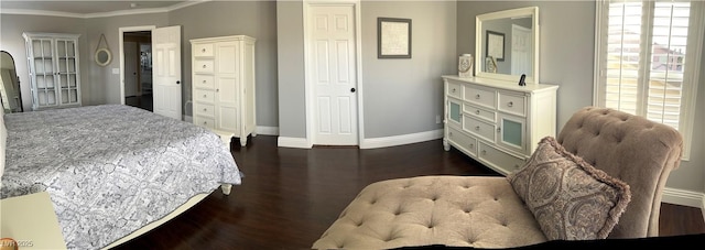 bedroom featuring baseboards, ornamental molding, and dark wood finished floors