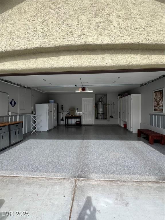 garage with freestanding refrigerator and secured water heater