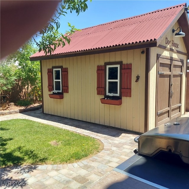 view of side of home featuring metal roof and an outdoor structure