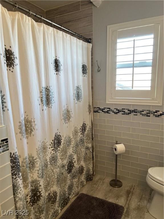 full bathroom featuring tile walls, toilet, tile patterned floors, and a shower with curtain