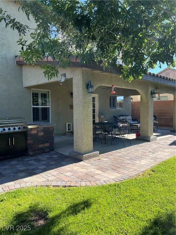 rear view of house with stucco siding and a patio