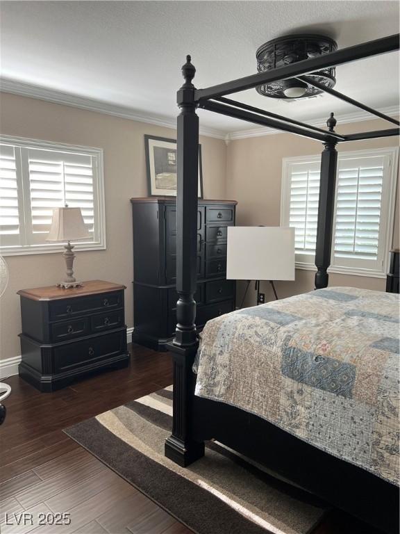 bedroom with crown molding, baseboards, and wood finished floors