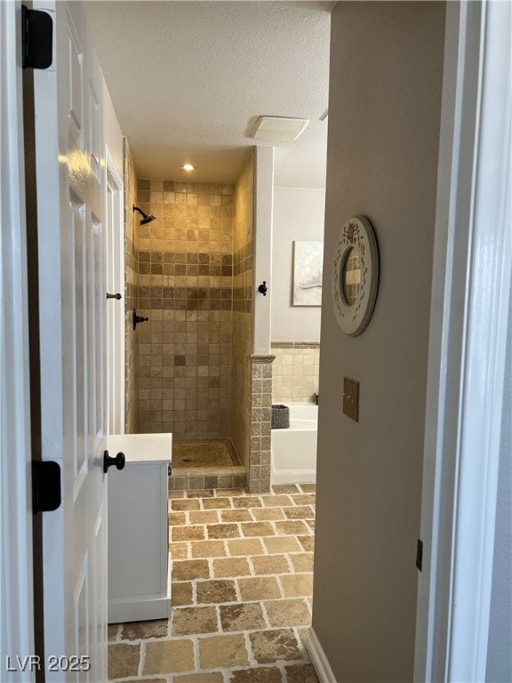 bathroom featuring a tile shower, a textured ceiling, brick flooring, a garden tub, and recessed lighting