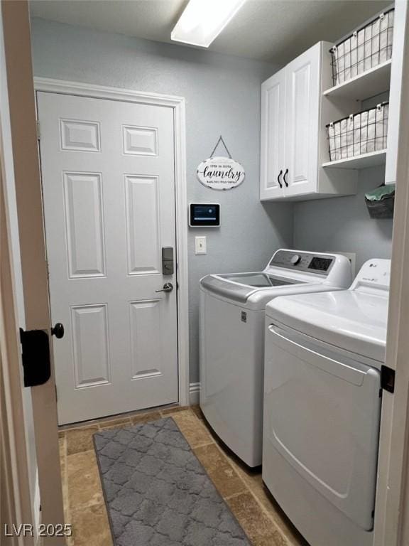 washroom with cabinet space, independent washer and dryer, and light tile patterned floors