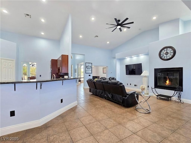 3780 Shawnee Ave, Pahrump, NV 89048 - living room with light tile patterned floors, ceiling fan, a glass covered fireplace, high vaulted ceiling, and recessed lighting