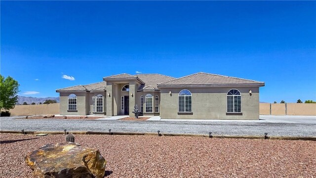 3780 Shawnee Ave, Pahrump, NV 89048 - view of front of house featuring stucco siding, fence, and a tiled roof
