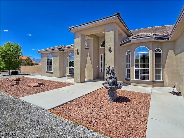3780 Shawnee Ave, Pahrump, NV 89048 - view of front facade featuring stucco siding, a patio, a tile roof, and fence