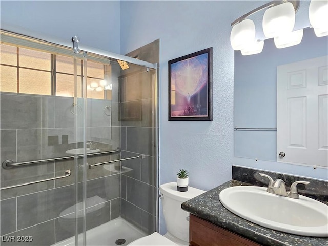 3780 Shawnee Ave, Pahrump, NV 89048 - full bathroom with a textured wall, vanity, a shower stall, and toilet