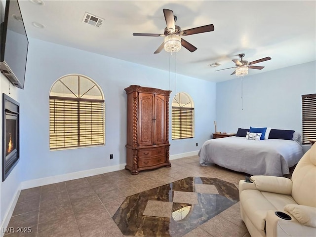 3780 Shawnee Ave, Pahrump, NV 89048 - bedroom featuring tile patterned flooring, baseboards, ceiling fan, and a warm lit fireplace