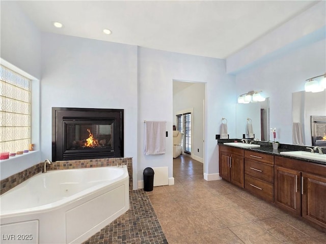 3780 Shawnee Ave, Pahrump, NV 89048 - bathroom featuring a garden tub, tile patterned flooring, healthy amount of natural light, a glass covered fireplace, and recessed lighting