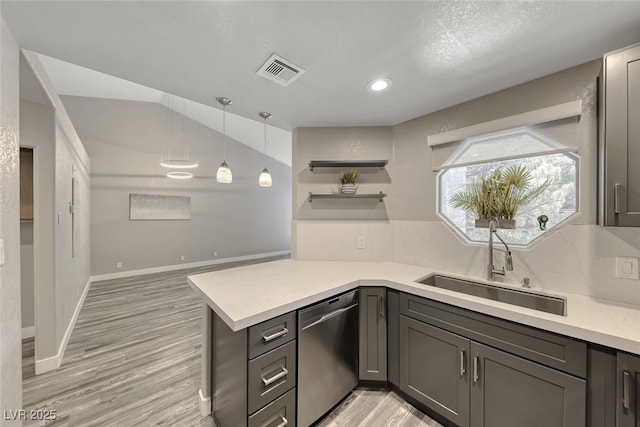 kitchen with stainless steel dishwasher, a sink, open shelves, light countertops, and light wood finished floors