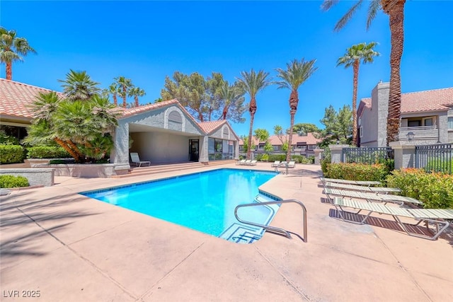 community pool featuring a patio and fence