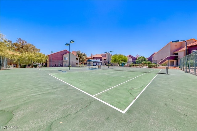 view of tennis court featuring fence