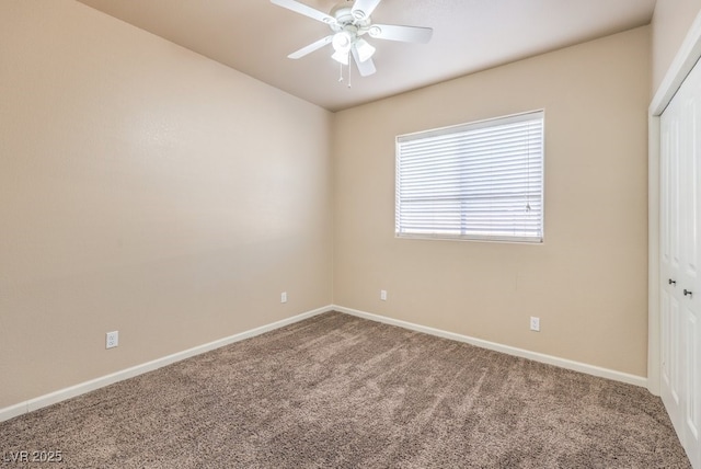 carpeted spare room featuring ceiling fan and baseboards