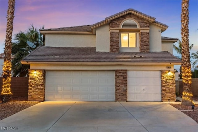 view of front facade with stone siding, stucco siding, driveway, and an attached garage