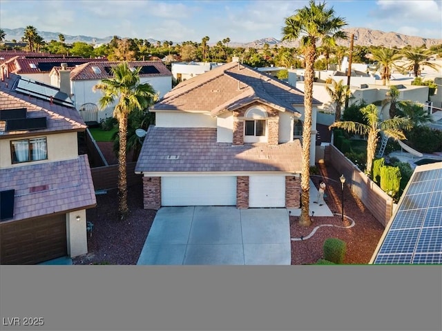 view of front of property with concrete driveway, a mountain view, and a residential view
