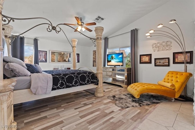 bedroom with light wood finished floors, vaulted ceiling, and ornate columns