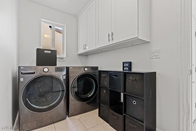 clothes washing area featuring washer and dryer, cabinet space, and light tile patterned floors