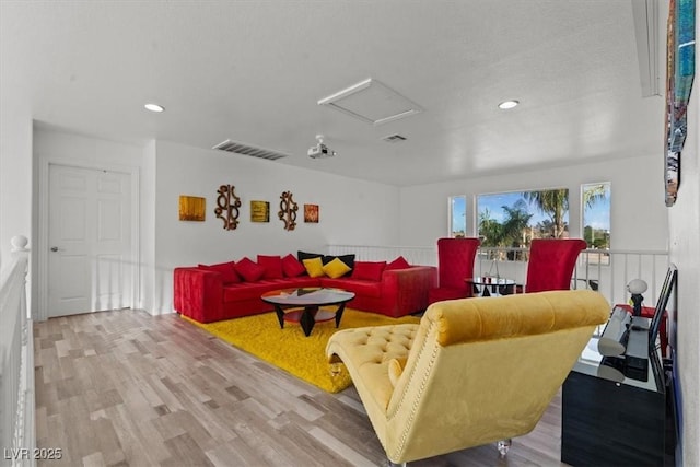 living room with attic access, light wood-type flooring, and recessed lighting
