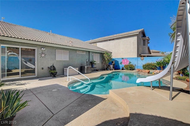 view of pool featuring a patio, a water slide, and central AC unit