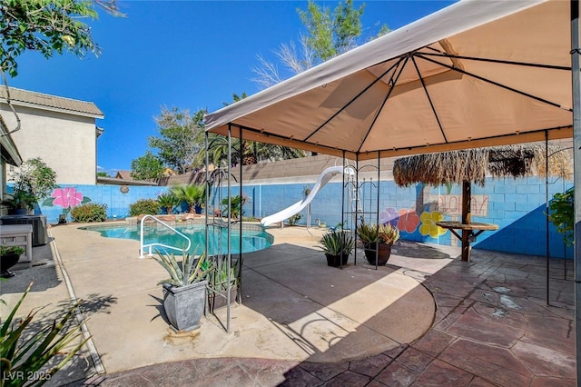 view of pool featuring a water slide, a gazebo, a fenced backyard, and a patio area