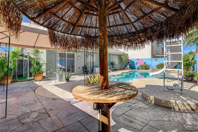 view of swimming pool featuring a water slide, a patio area, fence, and a gazebo