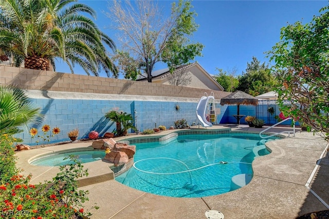 view of swimming pool featuring a water slide, a gazebo, a fenced backyard, a pool with connected hot tub, and a patio