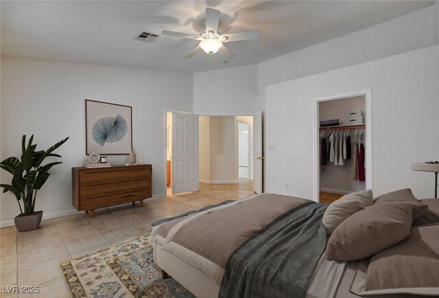 bedroom featuring tile patterned flooring, baseboards, a ceiling fan, a spacious closet, and lofted ceiling