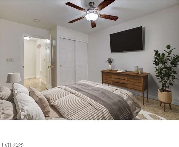 bedroom with a closet, ceiling fan, arched walkways, and baseboards