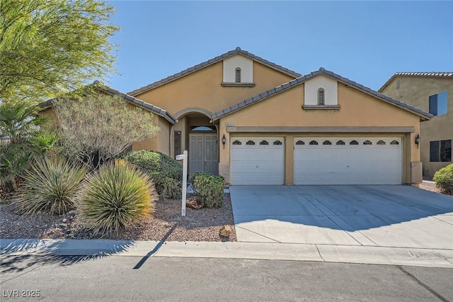 view of front facade with a garage, concrete driveway, stucco siding, and a tiled roof