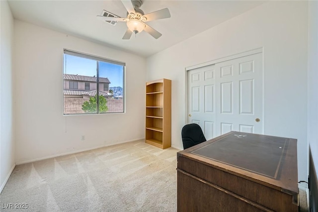 office space featuring light colored carpet, ceiling fan, and baseboards