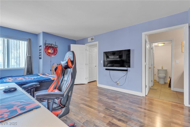 bedroom with wood finished floors and baseboards