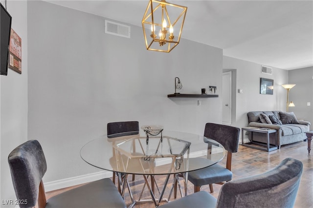 dining area with baseboards, a chandelier, and wood finished floors