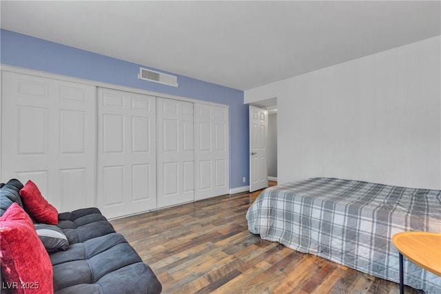 bedroom with wood finished floors, a closet, and baseboards
