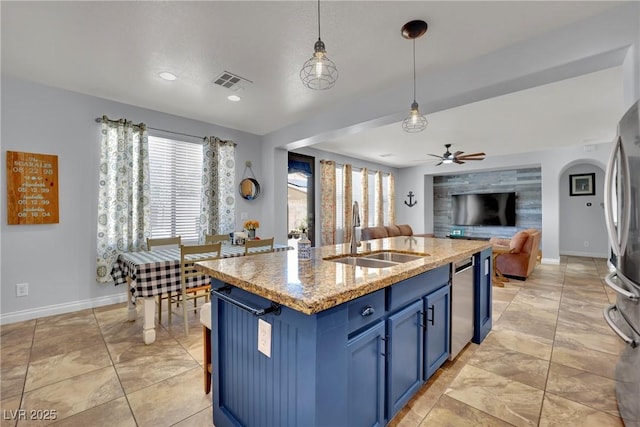 kitchen featuring a sink, blue cabinetry, ceiling fan, stainless steel appliances, and open floor plan