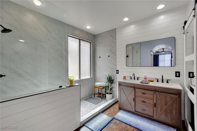 full bath with walk in shower, double vanity, wood finished floors, and recessed lighting